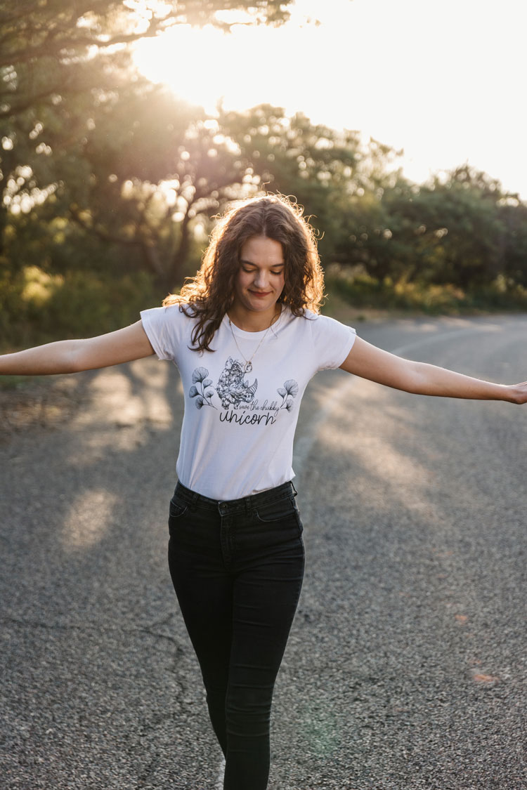 Woman in a white REPUBLK printed tee walking on a country road
